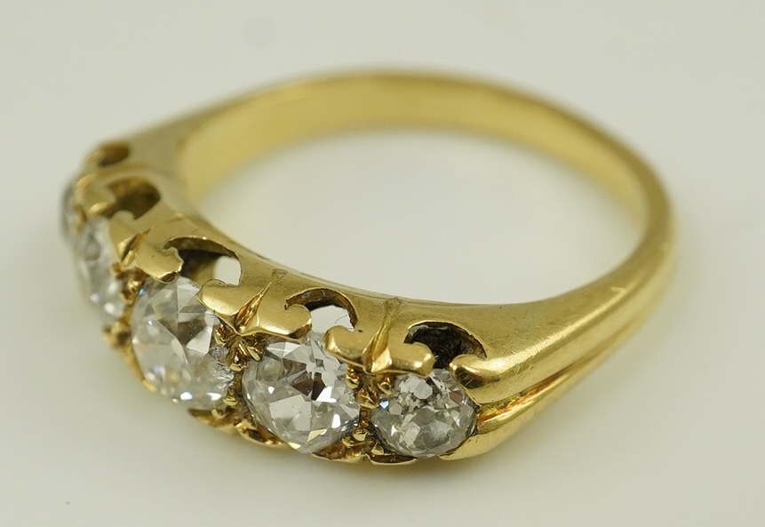 An antique gold and graduated five stone old mine cut diamond set half hoop ring